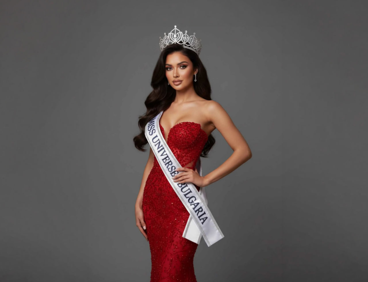 Anamaria Babau wearing a red gown, crown and Miss Universe Bulgaria sash